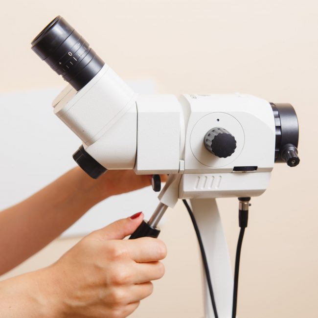 woman gynecologist working with colposcope in clinic